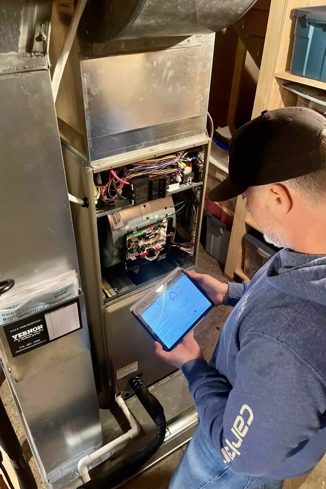 HVAC technician diagnosing a residential furnace on a dual fuel system