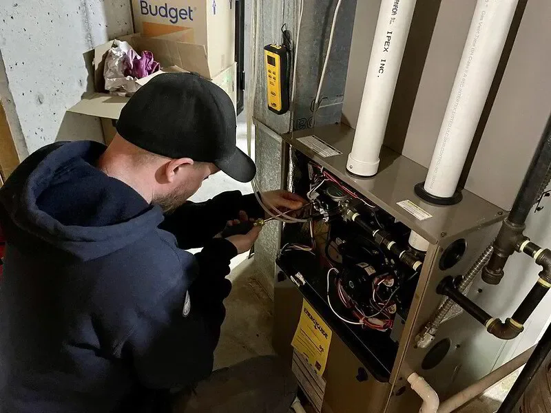 HVAC technician working on a furnace in a central HVAC system